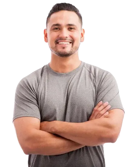 A smiling man with short dark hair and a beard, wearing a gray t-shirt and standing with his arms crossed.